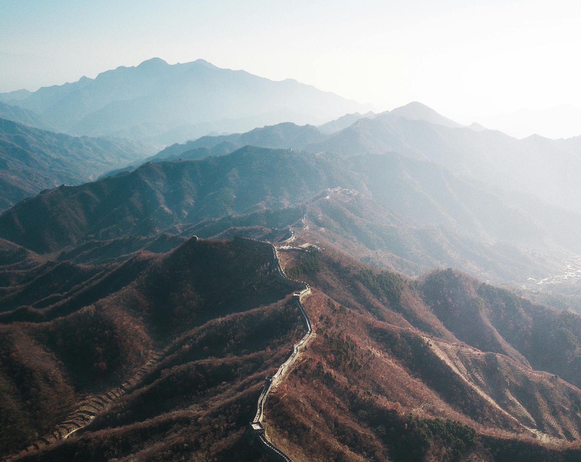 Stunning aerial shot of the Great Wall of China winding through mountains in autumn.